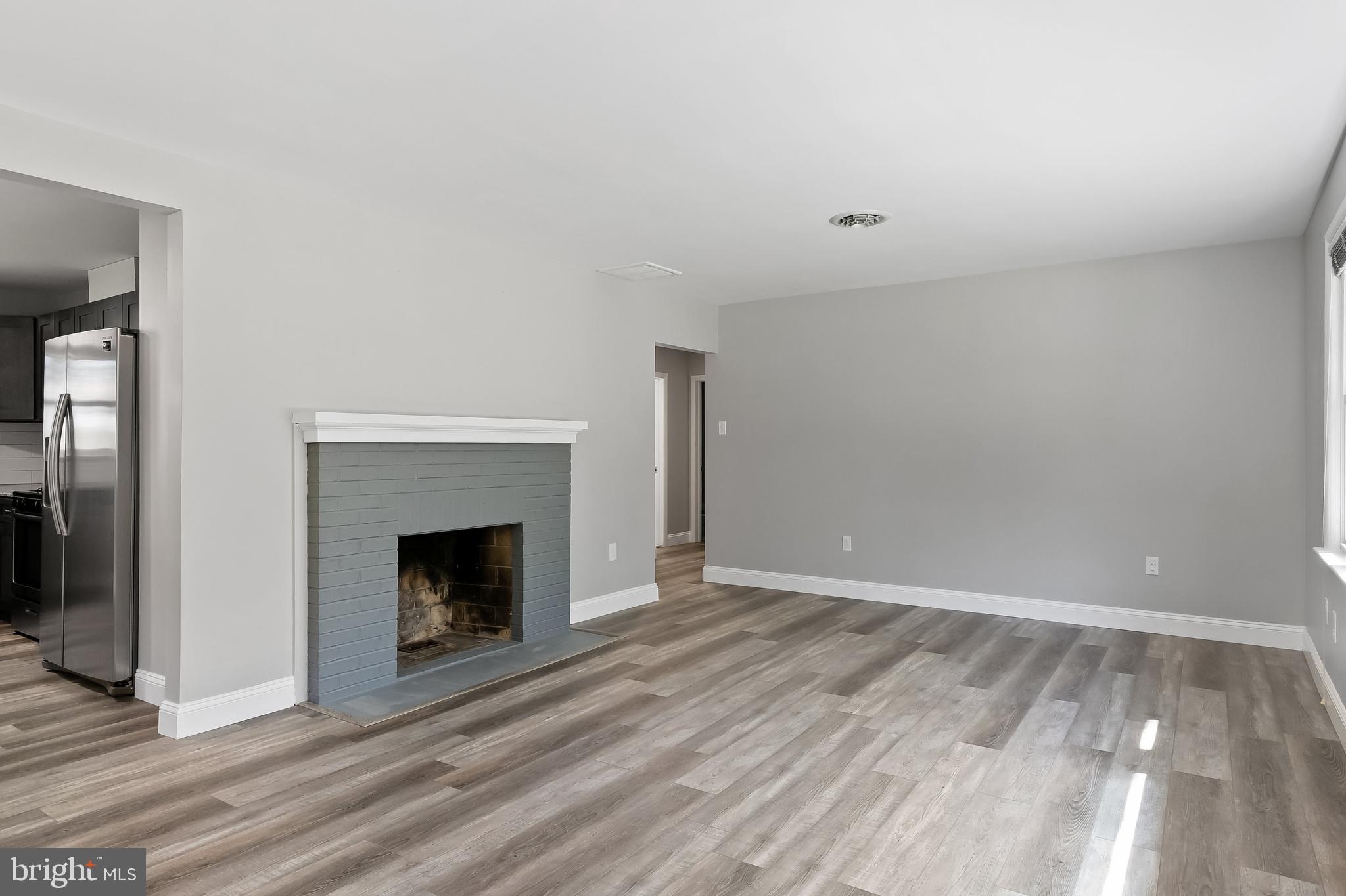 405 Hamilton Road Glassboro, NJ 08028 - Photo 4 of 28 a view of an empty room with wooden floor and a fireplace