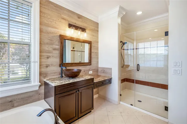 a bathroom with a granite countertop sink a mirror and a bathtub