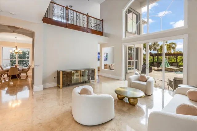 a living room with furniture a rug a lamp and a large window