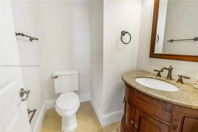 a bathroom with a granite countertop toilet sink and a mirror