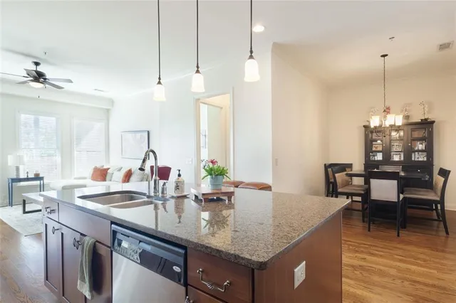 a kitchen island with granite countertop a sink and a wooden floor
