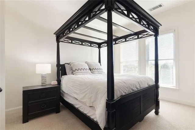 a bed sitting in a bedroom next to a window