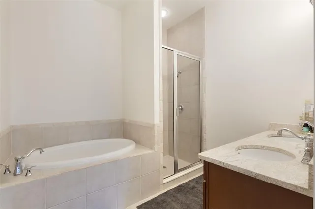 a bathroom with a granite countertop sink and a bathtub