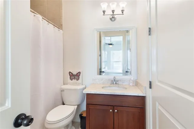 a bathroom with a sink vanity mirror and toilet