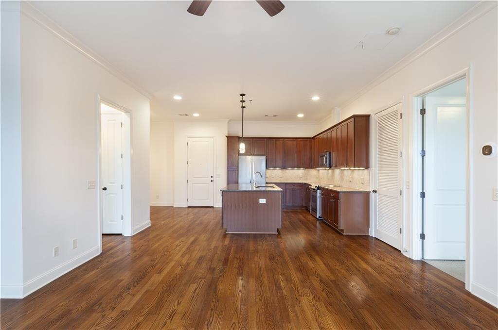 360 Chambers Street, Unit 208 Woodstock, GA 30188 - Photo 21 of 46 a large kitchen with stainless steel appliances kitchen island a large counter top and wooden floors