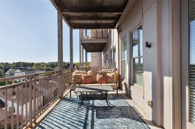 a balcony with wooden floor and outdoor seating
