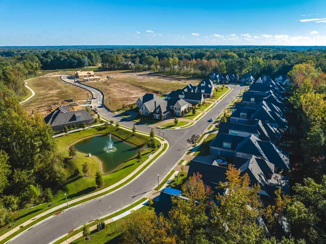 a spacious bedroom with a bed a dresser and a chandelier