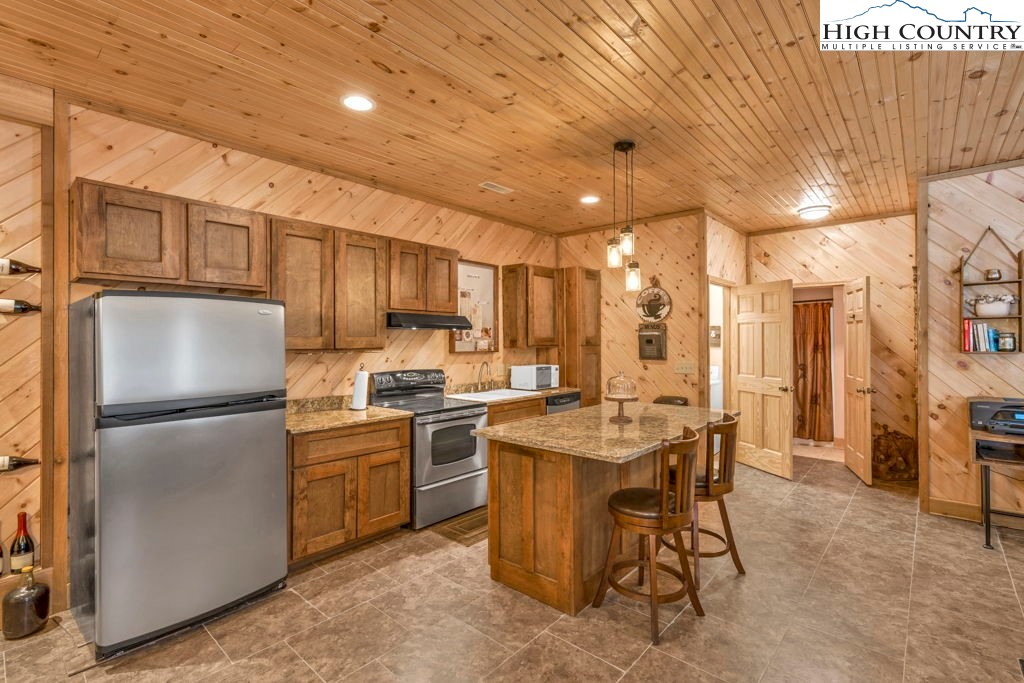 173 Spring Brook Road Newland, NC 28657 - Photo 27 of 39 a kitchen with appliances a sink a counter and chairs