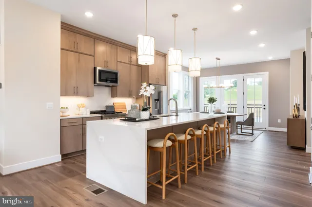 a large kitchen with kitchen island a large island a stove a sink a dining table and chairs