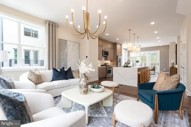 a living room with furniture kitchen and a chandelier