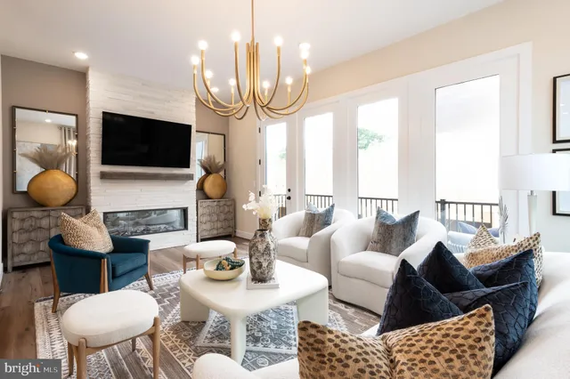 a living room with furniture a flat screen tv and a large window