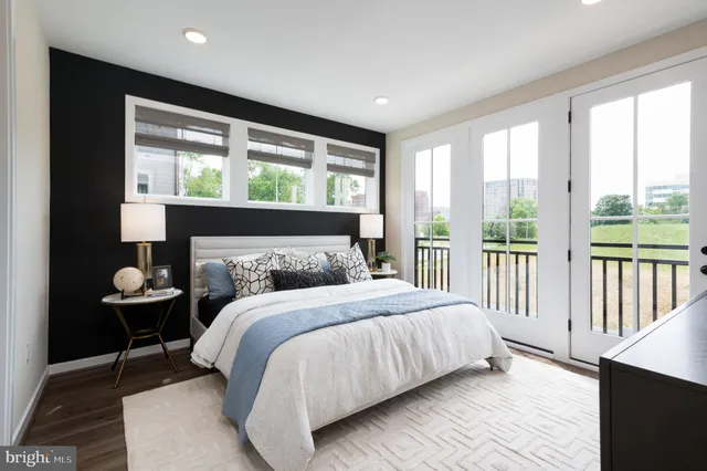 a bedroom with a bed and a large window