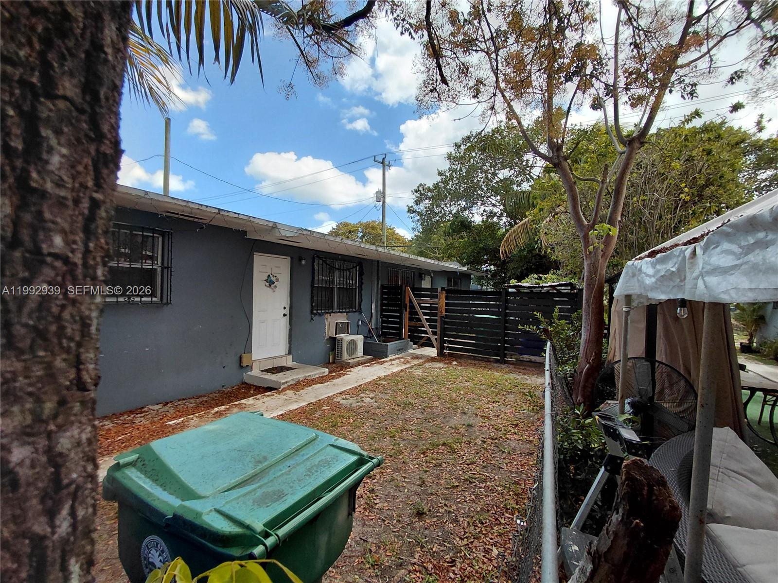 1262-1264 Northwest 46th Street Miami, FL 33142 - Photo 1 of 13 a view of house with backyard outdoor seating and trees