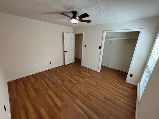 a view of empty room with wooden floor