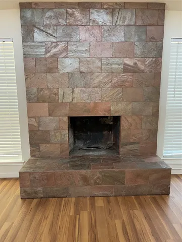 a room with a wooden floor and a fireplace