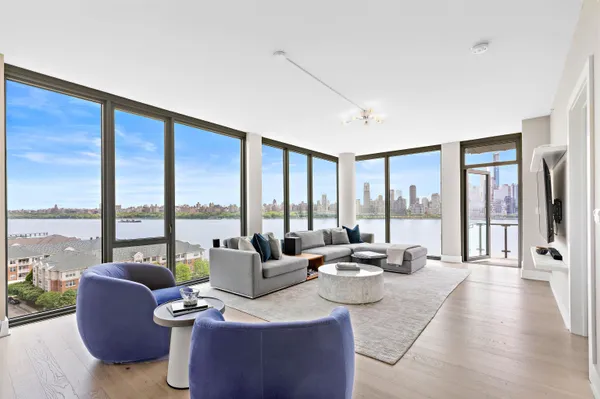 a living room with furniture and floor to ceiling windows