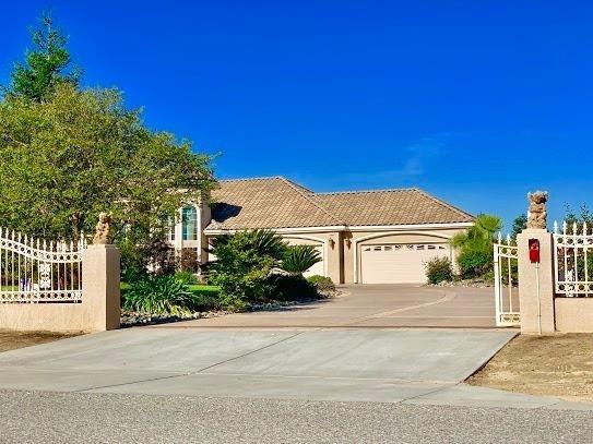 21196 Steward Road Madera, CA 93638 - Photo 4 of 39 a view of a white house with a large tree with plants