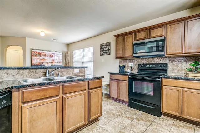 a kitchen with stainless steel appliances granite countertop a stove sink microwave and cabinets