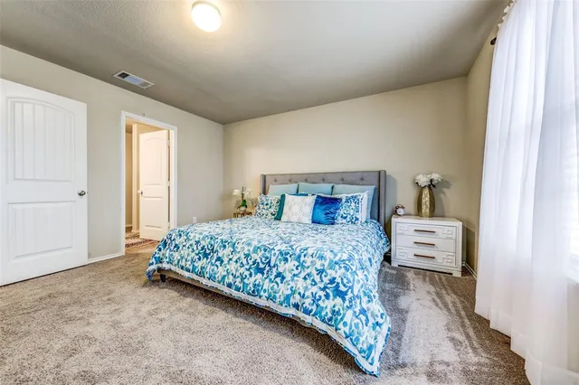 a bedroom with a large bed and a window