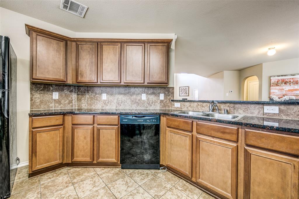 1774 Pioneer Way Lancaster, TX 75146 - Photo 5 of 23 a kitchen with stainless steel appliances granite countertop a stove a sink and a microwave