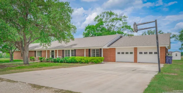 front view of house with a yard and potted plants