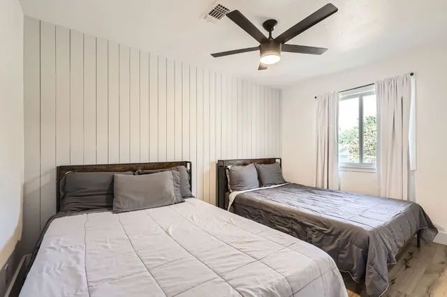 a bedroom with two beds and painting on the wall