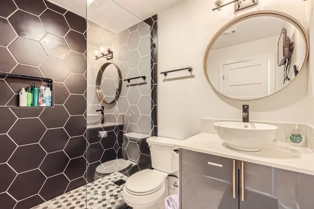 a bathroom with a sink mirror vanity and toilet