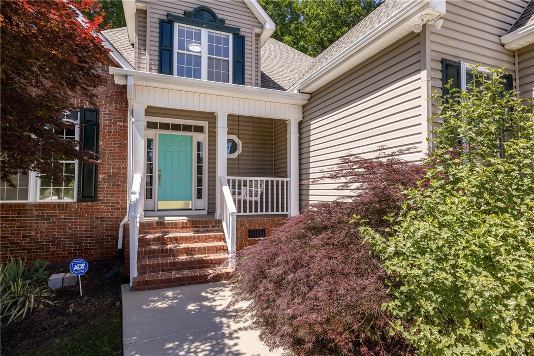 110 Brookstone Way Central, SC 29630 - Photo 5 of 46 This charming home showcases a welcoming front porch, brick details, and a neatly manicured landscape.