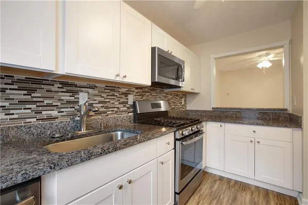 a kitchen with wooden floors and stainless steel appliances