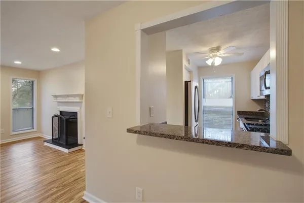 a view of a room with wooden floor and a ceiling fan