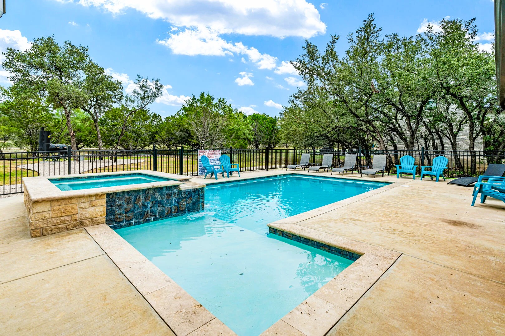 1718 Mountain Valley Road Concan, TX 78838 - Photo 34 of 40 A spacious concrete patio surrounds an inviting in-ground pool accented by a raised spa.