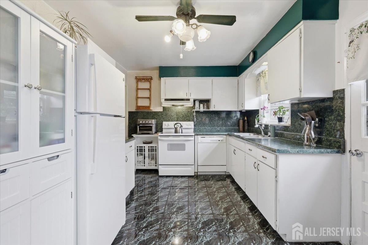 33 Ellison Road Somerset, NJ 08873 - Photo 9 of 38 a kitchen with white cabinets and stainless steel appliances