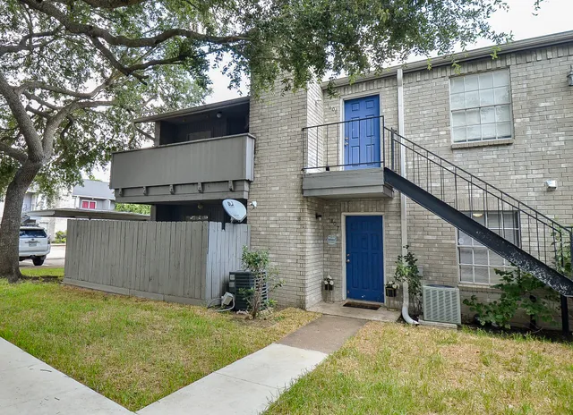 a view of a house with a yard and large tree