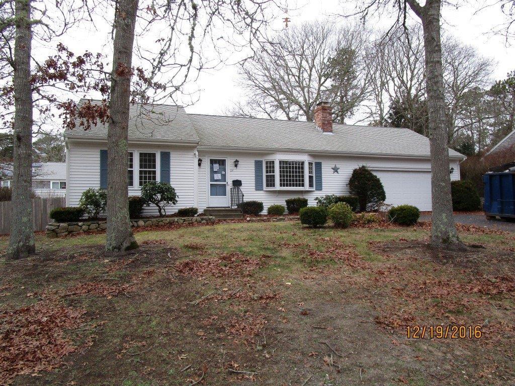 a front view of house with yard and trees around
