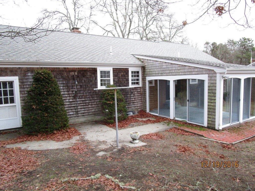 64 McNamara Road West Yarmouth, MA 02673 - Photo 11 of 14 a front view of a house with a yard and garage