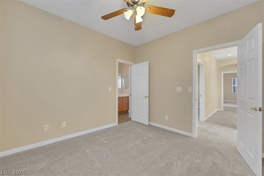 10328 Hawk Ravine Street Las Vegas, NV 89178 - Photo 29 of 55 A comfortable bedroom with plush carpeting and a convenient en-suite bathroom.
