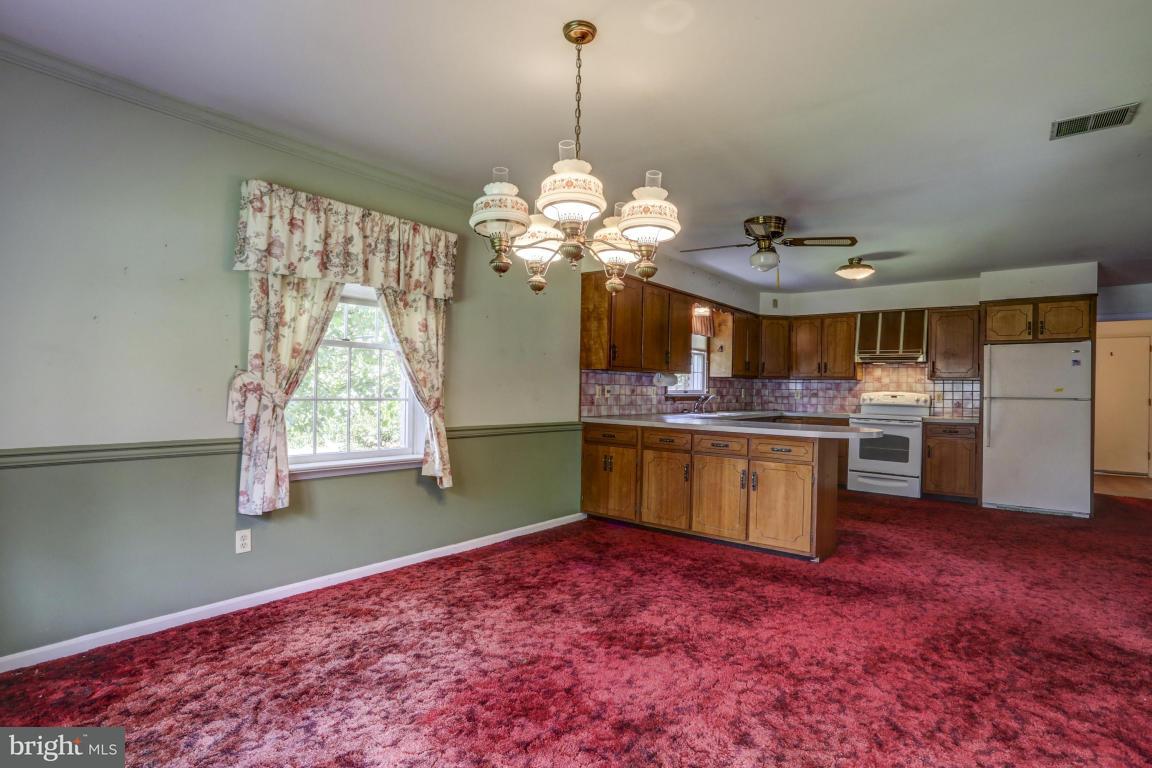 411 South Belmont Road Paradise, PA 17562 - Photo 6 of 25 a kitchen with kitchen island granite countertop a stove a sink dishwasher and a wooden cabinets