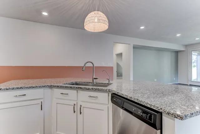 a kitchen with granite countertop cabinets and chandelier