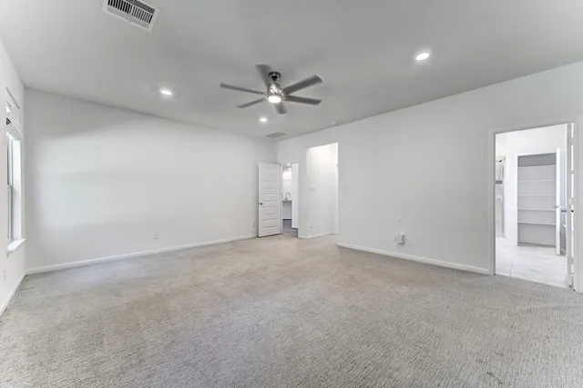 an empty room with fan and windows