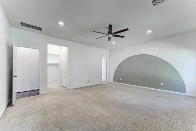 an empty room with a ceiling fan and window