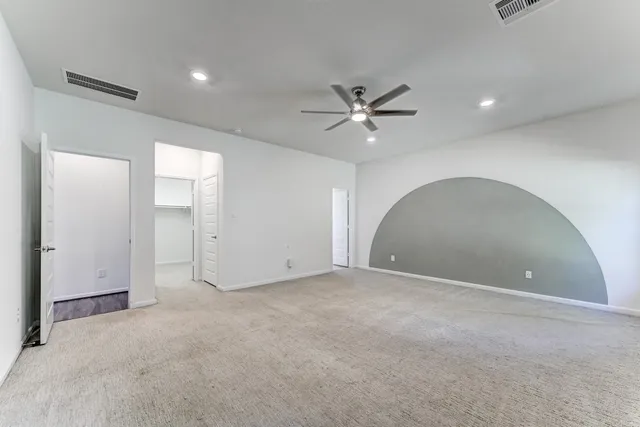 an empty room with a ceiling fan and a bathroom