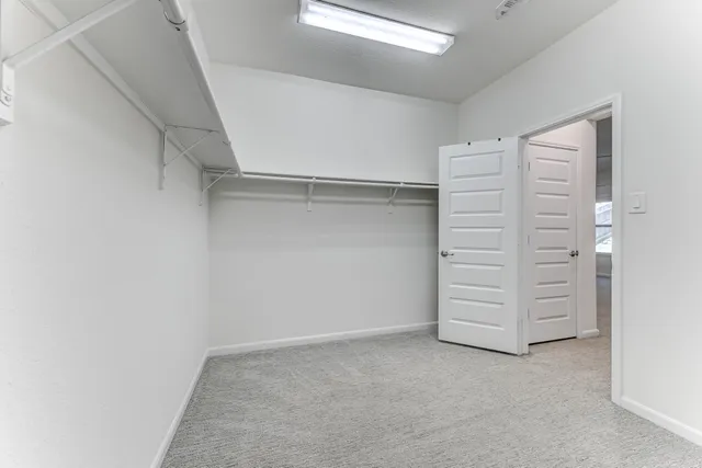 a view of walk in closet with clothes