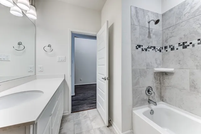 a bathroom with a tub sink and mirror