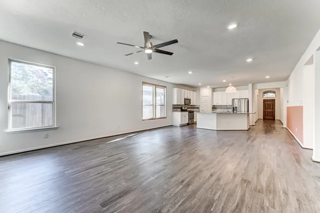 a view of empty room with wooden floor and window