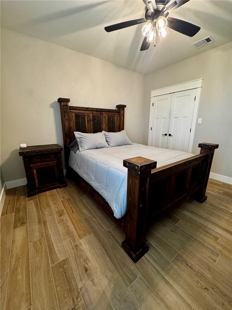 5854 Reliance Rdg Circle Bryan, TX 77808 - Photo 25 of 32 a bedroom with a bed and wooden floor