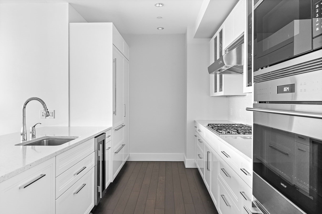 22 Liberty Drive, Unit 4D Boston, MA 02210 - Photo 8 of 21 a kitchen with white cabinets and appliances