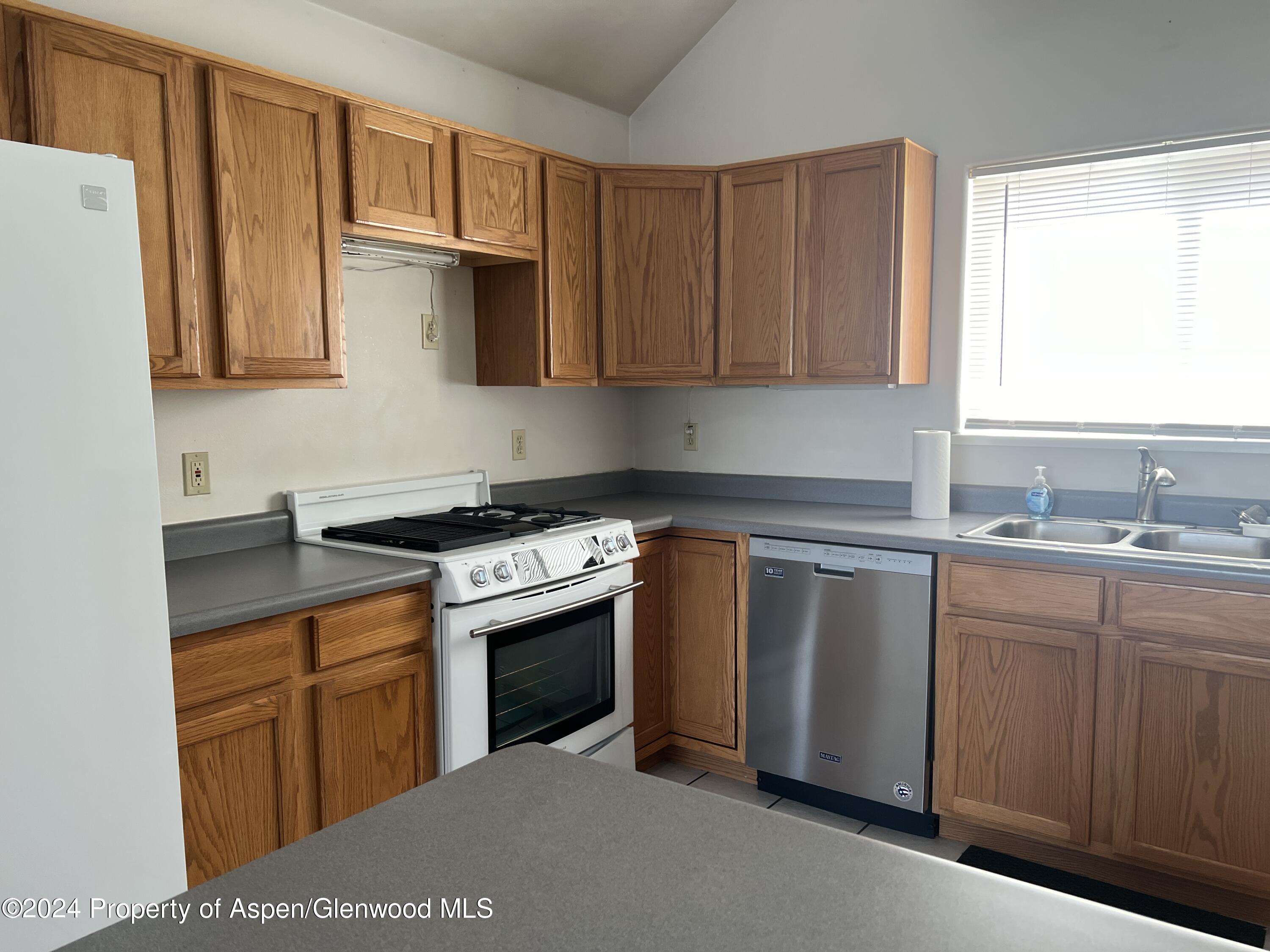 424 Lind Avenue Rifle, CO 81650 - Photo 7 of 24 a kitchen with stainless steel appliances granite countertop a sink stove and refrigerator