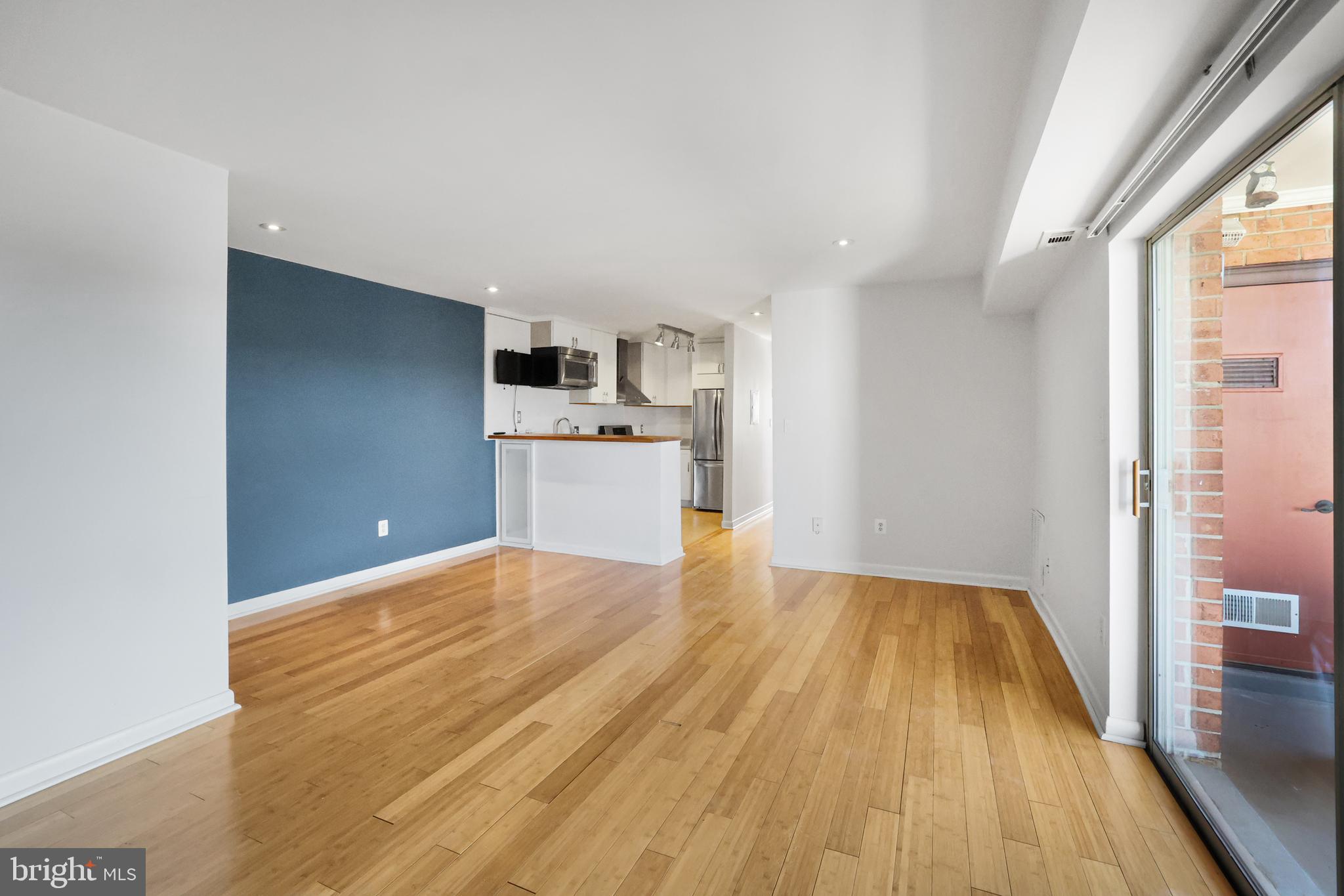 a view of a kitchen with wooden floor and a sink