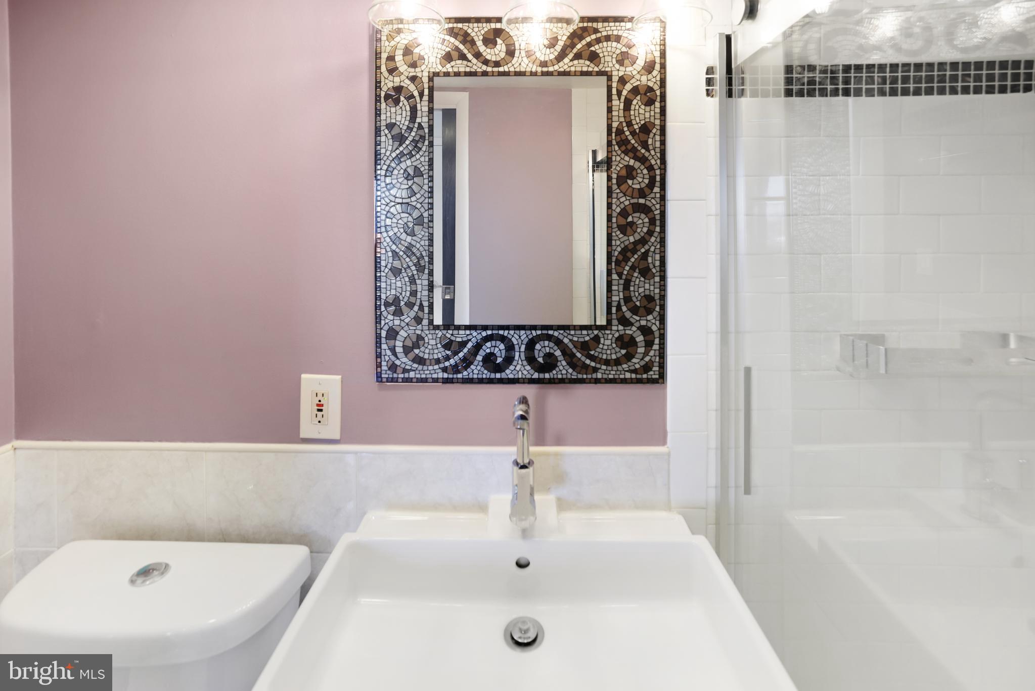 2634 Bowen Road Southeast, Unit 404 Washington, DC 20020 - Photo 11 of 15 a bathroom with a bathtub sink and mirror