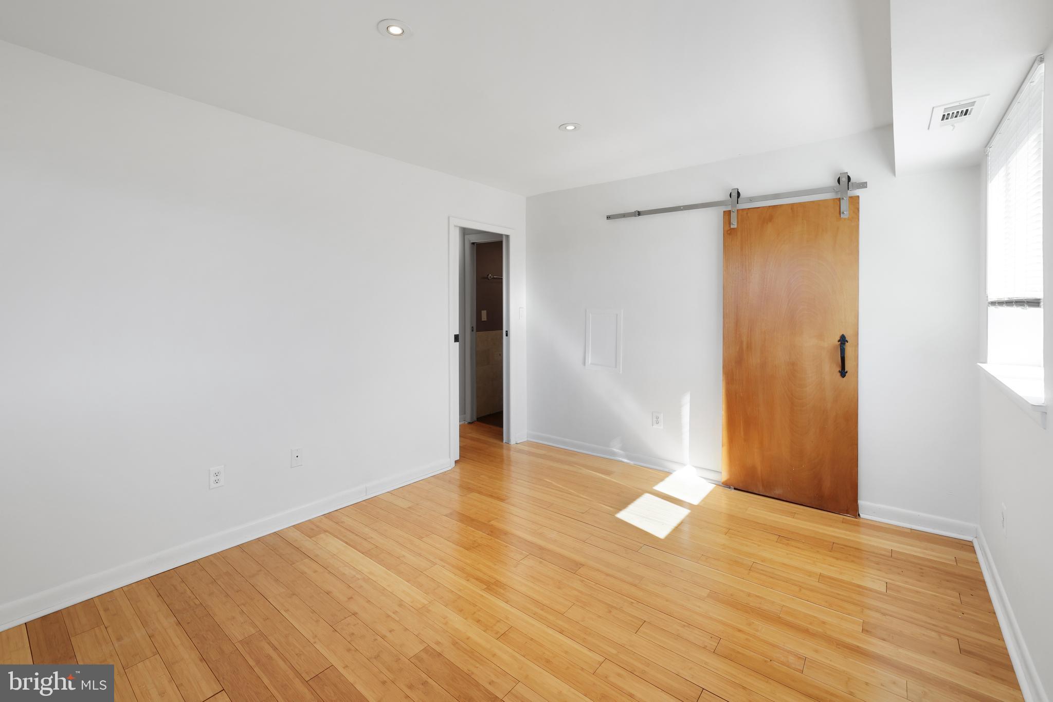 2634 Bowen Road Southeast, Unit 404 Washington, DC 20020 - Photo 13 of 15 a view of an empty room with wooden floor and a window